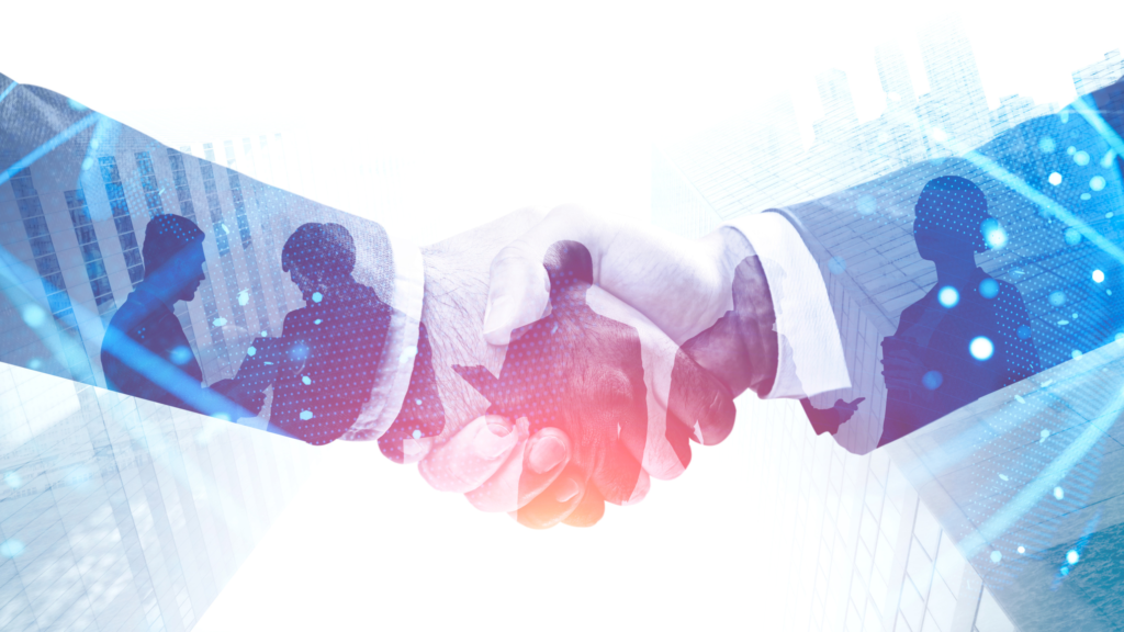 Two people are shaking hands. Reflected in their hands and arms are other business men and women. 