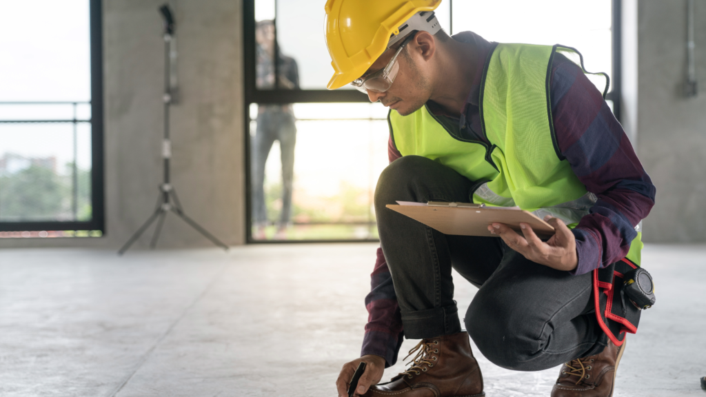 A construction worker inspects a problem with the floor in a new building. Defects in design or constrution can lead to Florida construction litigation. 